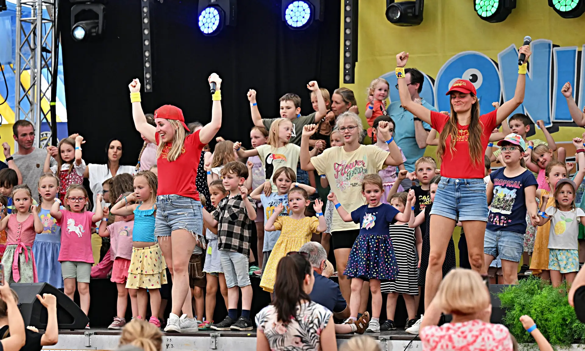 Gruppenbild des Duos Donikkl-Crew mit feiernden und tanzenden Kindern